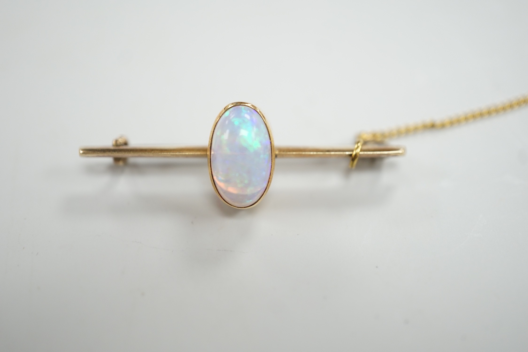 A yellow metal and single stone oval white opal set bar brooch, 39mm, gross weight 4.3 grams.